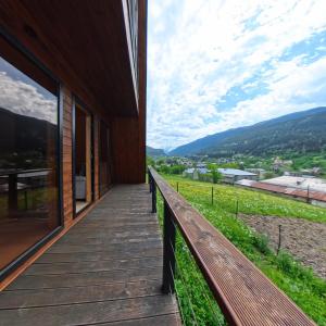 een houten loopbrug aan de zijkant van een huis met uitzicht bij A-frame Wonder in Mestia