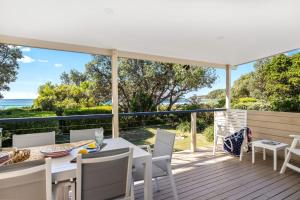 モリーモックにあるBeachfront Bliss on Mollymook Beachのデッキにテーブルと椅子が置かれたパティオ