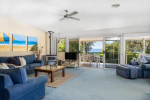 モリーモックにあるBeachfront Bliss on Mollymook Beachのリビングルーム(青いソファ、テレビ付)