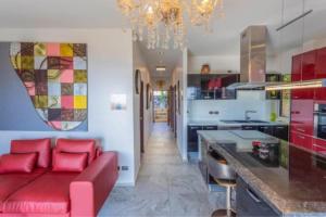 a living room with a red couch in a kitchen at Karon Sunset Seaview Villa by 789property in Karon Beach