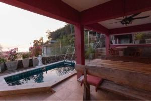 a patio with a bench and a swimming pool at Karon Sunset Seaview Villa by 789property in Karon Beach