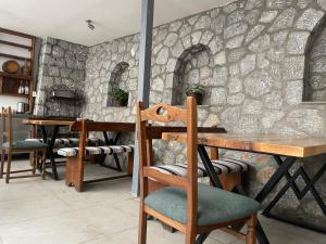 Cette chambre est dotée de tables, de chaises et d'un mur en pierre. dans l'établissement Villa Lira, à Ohrid