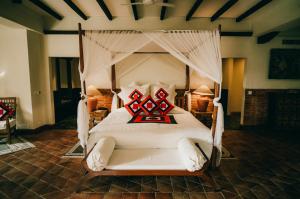 a bedroom with a large white bed with red pillows at The Dwarika's Hotel in Kathmandu
