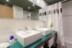 a white bathroom with two sinks and a mirror at Ciutat de Barcelona in Barcelona