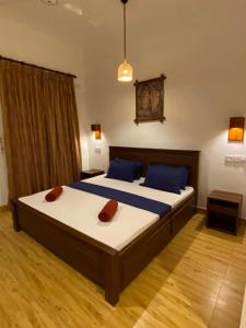 a bedroom with two beds with blue pillows at Oasis Bay - Arugam Bay in Arugam Bay