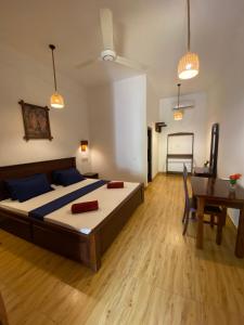 a bedroom with a large bed and a table at Oasis Bay - Arugam Bay in Arugam Bay