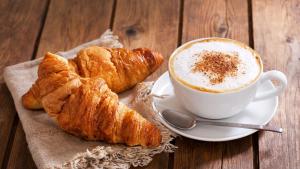 a cup of coffee and croissants on a table at "Da Nina" in Lascari