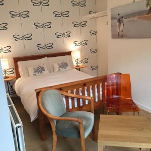 a bedroom with a bed and a chair and a table at Lovat House in Crieff