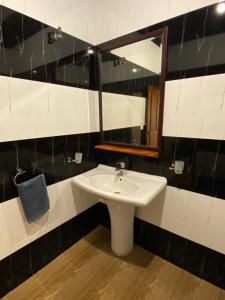 a bathroom with a white sink and a mirror at Oasis Bay - Arugam Bay in Arugam Bay