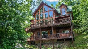 a large wooden house with a wrap around deck at Majestic Manor - Peaceful Modern Cabin Retreat Near Watauga Lake in Butler
