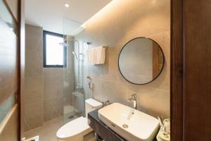 a bathroom with a sink and a mirror and a toilet at Crescendo Limitless Style in Hanoi +88 photos