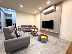 a living room with a couch and a tv at Travel Happiness Homestay in Huxi