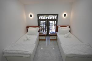 twee bedden in een kamer met een raam bij Kamilovs' Hotel in Tasjkent