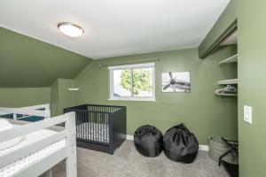 a green bedroom with a crib and a window at Love 'n Life Haven in Cincinnati