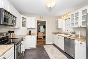 a kitchen with white cabinets and stainless steel appliances at The Cincinnati Charm in Cincinnati