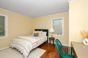 a bedroom with a bed and a desk and two windows at The Cincinnati Charm in Cincinnati
