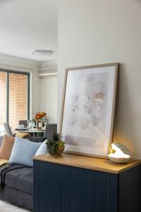 Una sala de estar con un sofá y un cuadro. en Free Parking on Bunn, 5 mins to The Star & Darling, en Sídney