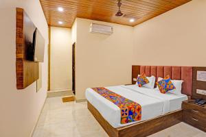Un dormitorio con una cama y un televisor. en FabExpress Surya Grand, en Bombay