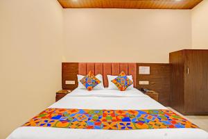 Un dormitorio con una cama con un edredón colorido. en FabExpress Surya Grand, en Bombay