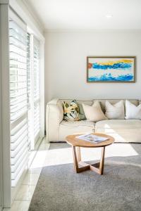 a living room with a couch and a coffee table at Spacious Coastal Retreat, Ideal for Families in Mangawhai