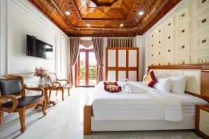 a bedroom with a large white bed and a table at HÙNG MIAMI HOTEl - 3 SAO in Ho Chi Minh City