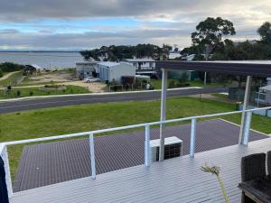 Una terraza con vista al agua y a la carretera. en The Lakehouse Lochsport, en Lock Sport