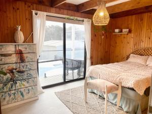 Un dormitorio con una cama y una puerta corrediza de vidrio. en The Lakehouse Lochsport, en Lock Sport