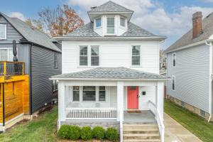 ein weißes Haus mit einer roten Tür in der Unterkunft The Restful Roost w Hot Tub in Columbus