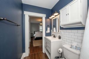 ein Badezimmer mit einem weißen Waschbecken und einer blauen Wand in der Unterkunft The Restful Roost w Hot Tub in Columbus + 16 Fotos