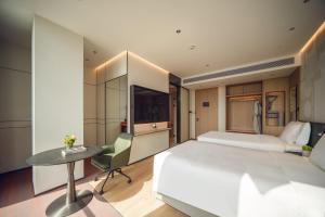 a bedroom with a bed and a desk and a table at EVEN Hotel Shanghai Jinqiao by IHG in Shanghai