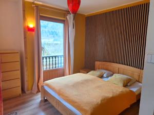 sypialnia z łóżkiem i dużym oknem w obiekcie Adventure House w mieście Palfau