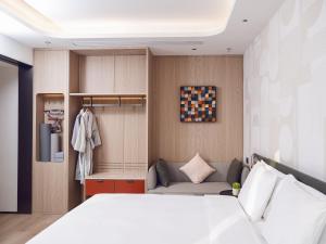 a bedroom with a white bed and a couch at EVEN Hotel Shanghai Jinqiao by IHG in Shanghai