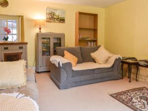a living room with a gray couch and a fireplace at Laurel Farm in Rolstone