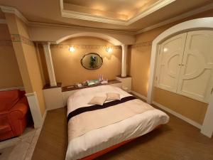 Un dormitorio con una cama grande en una habitación. en ホテル湯島御苑水戸店, en Mito