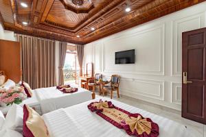 a hotel room with two beds and a television at HÙNG MIAMI HOTEl - 3 SAO in Ho Chi Minh City +52 photos
