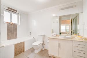 Un baño blanco con inodoro y lavabo. en Rivergrande Apartment, en Innisfail 21 fotos más