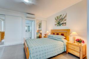 Un dormitorio con una cama y una mesa con flores. en Rivergrande Apartment, en Innisfail