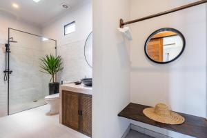 a bathroom with a sink and a toilet and a mirror at Villa Gaia Canggu in Canggu