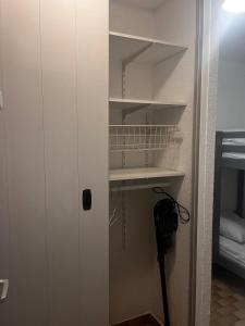 einen Schrank mit einer weißen Tür und einem Regal in der Unterkunft Studio avec vue sur le port in Mauguio