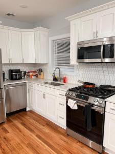 a kitchen with white cabinets and a stove top oven at The great homes in East Orange +11 photos