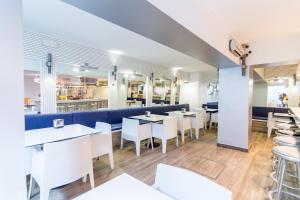a restaurant with white tables and white chairs at Colors in Barcelona
