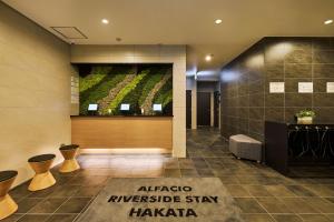 a hotel lobby with a large painting on the wall at ALFACIO RIVERSIDE STAY HAKATA in Fukuoka