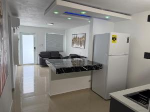 a kitchen with a white refrigerator and a living room at Costa Relax - 5 in Arroyo