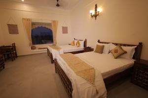 En eller flere senge i et værelse på Agastya Vilas Resort