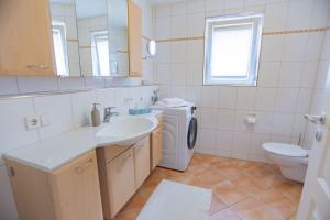 a bathroom with a sink and a washing machine at Ferienwohnung bei Hotel Ochsen in Ammerbuch in Ammerbuch