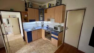 a kitchen with wooden cabinets and a microwave at Bolehost in Bolehošťská Lhota