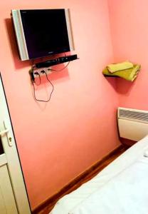 a television on the wall of a room with a bed at Cozy corner Dilijan in Dilijan