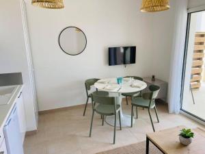 a dining room with a table and chairs and a tv at T3 bord de mer en Corse N130 in Linguizzetta