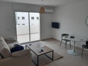 a living room with a couch and a table at T3 bord de mer en Corse N130 in Linguizzetta