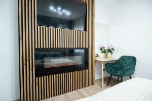 een slaapkamer met een open haard, een bed en een stoel bij Design Green Garden Apartments with Private Parking & Playground in Rīga